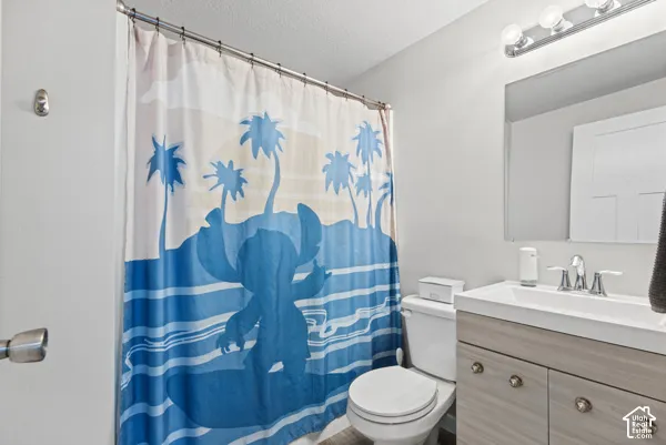 Bathroom with a single vanity, light wood-finish cabinetry, and a chrome faucet