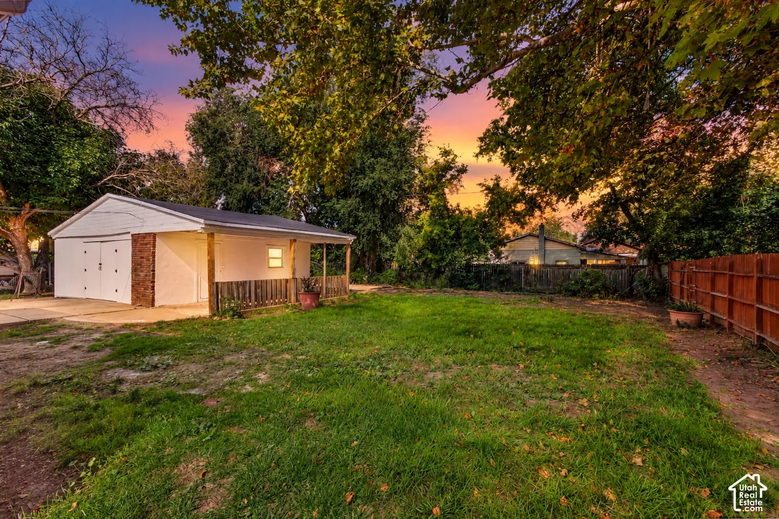 Detached garage featuring dual doors, brick accents, and an attached covered patio
