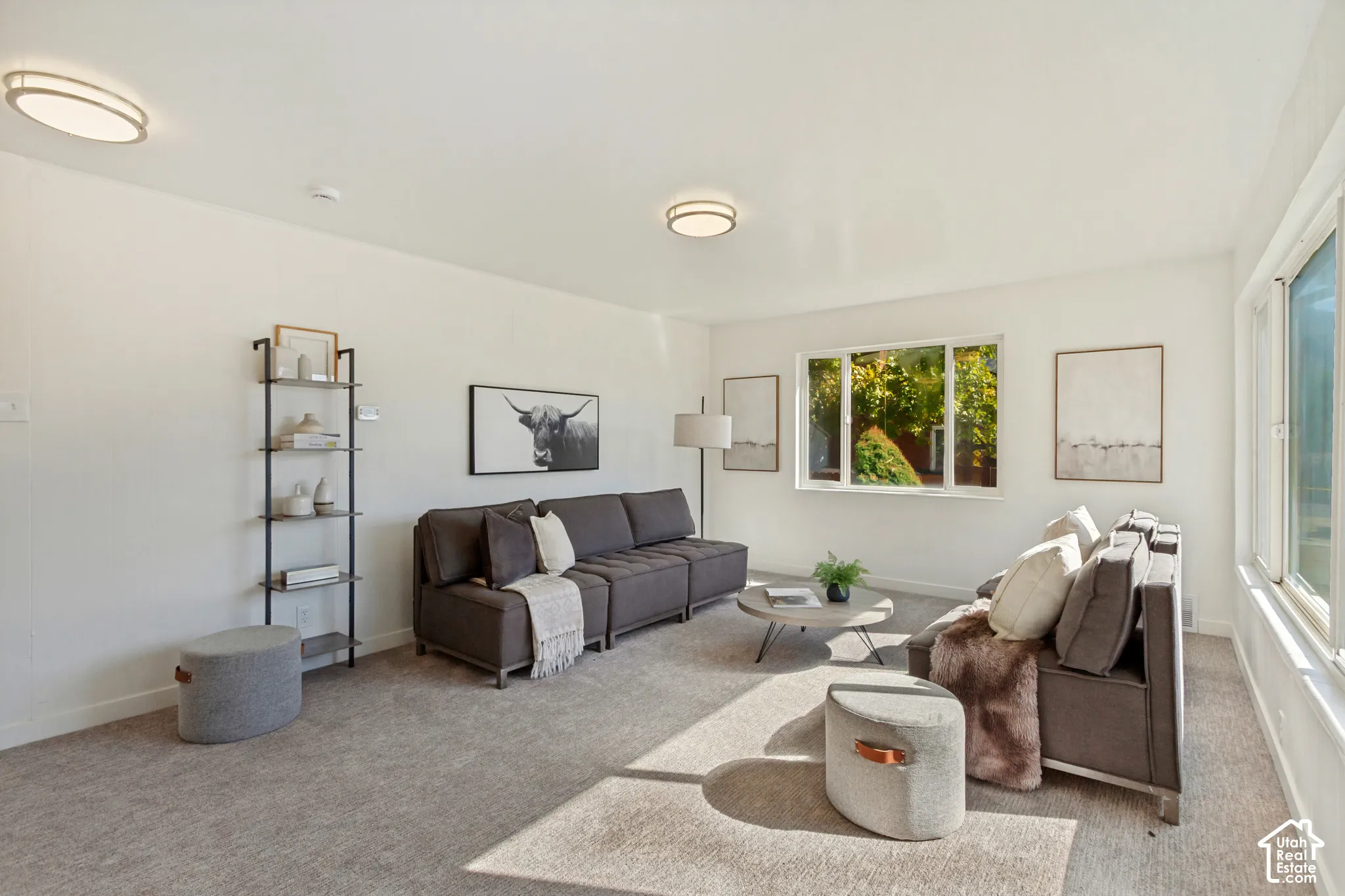 Bright living space featuring broad windows, recessed lighting, and light-toned carpeting throughout