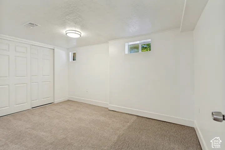 Neutral carpet flooring, white walls, built-in sliding closet doors, and recessed windows