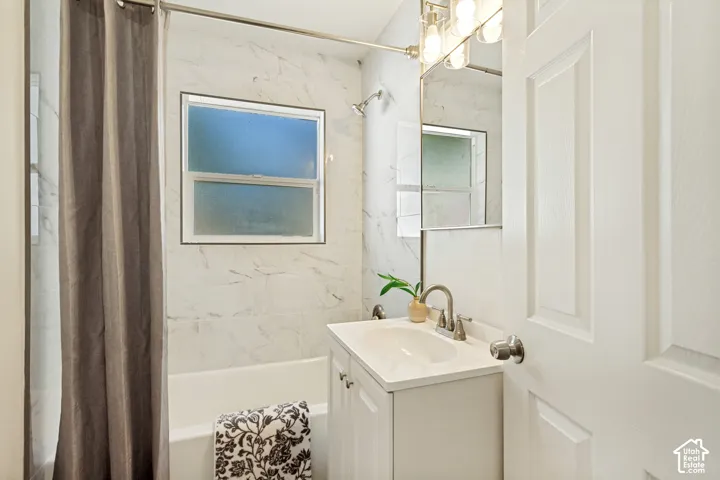 Bathroom with a white vanity, integrated sink, and brushed nickel fixtures