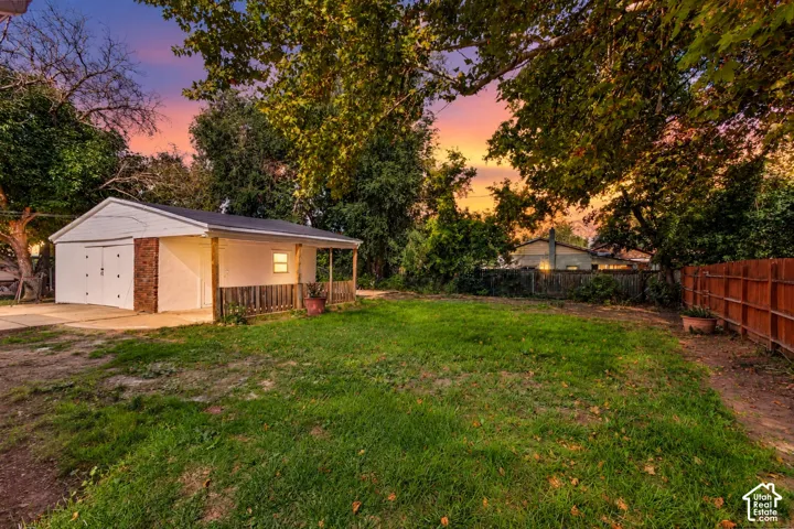 Detached garage featuring dual doors, brick accents, and an attached covered patio
