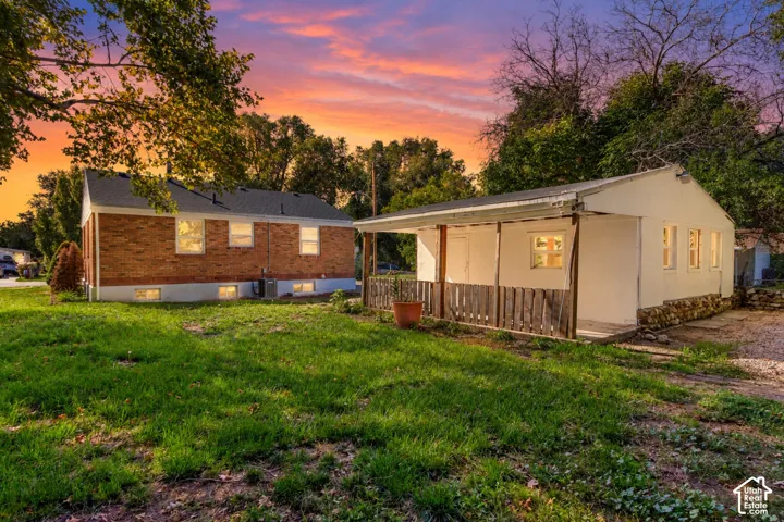 Brick exterior residence with a separate white structure featuring an extended covered porch