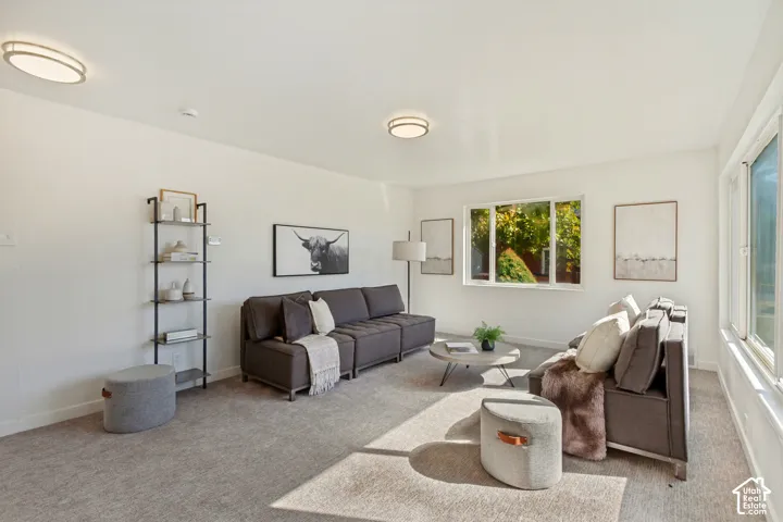 Bright living space featuring broad windows, recessed lighting, and light-toned carpeting throughout