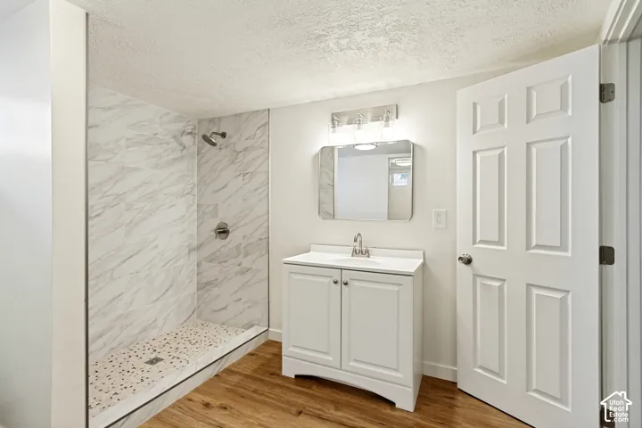 Walk-in shower with tiled walls and pebble-finish floor