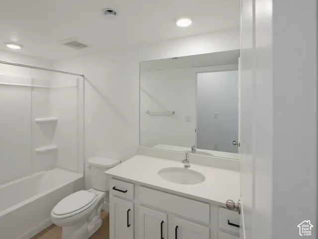 White vanity with a light-toned countertop, single basin sink, and chrome faucet
