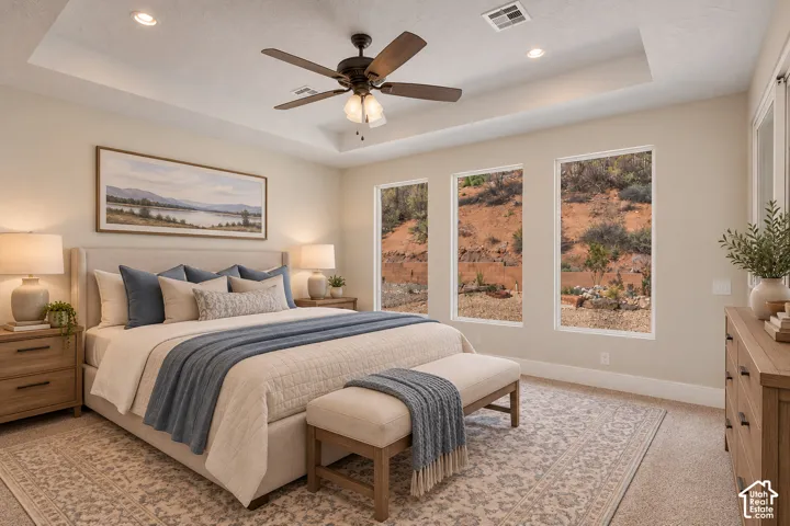Recessed lighting illuminates the tray ceiling and ceiling fan