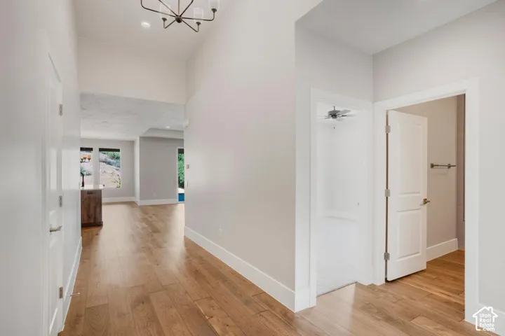 Hardwood-style flooring throughout, high ceilings, recessed lighting, and a modern chandelier
