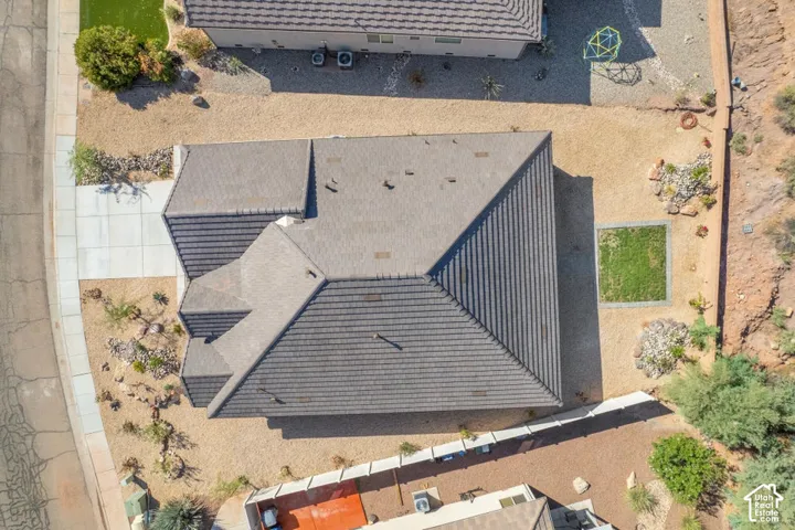 Pitched tile roofing with an expansive gravel yard and concrete driveway