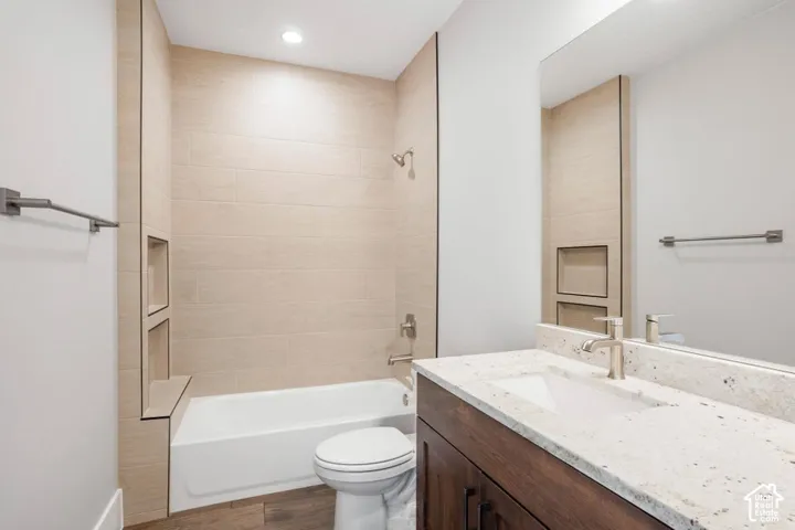 Bathtub with tiled surround, recessed shower niches, and an integrated bench