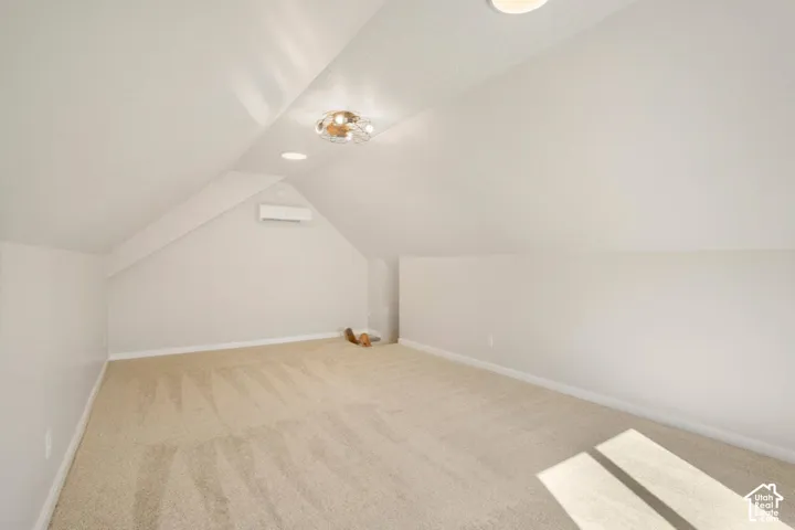 Recessed lighting, contemporary ceiling fixture, light-toned carpeting, mini-split climate control system, and sloped ceilings