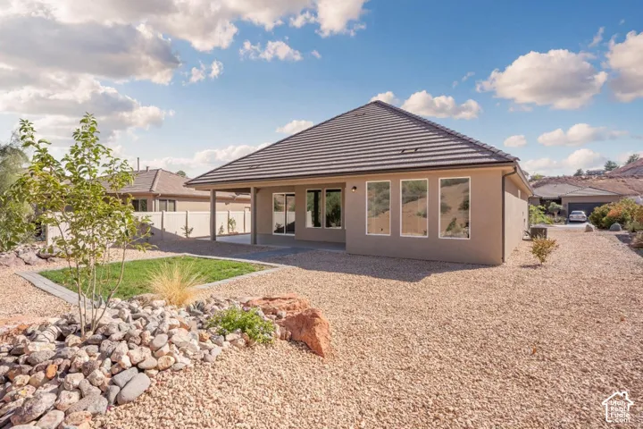 Modern residential home featuring a tapered metal roof with standing-seam detailing, expansive multi-pane window wall system, and warm neutral exterior finishes