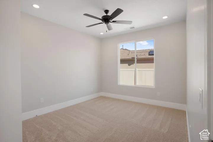 Neutral tone wall paint, recessed ceiling lighting, ceiling fan with light fixture, single window, and carpet flooring