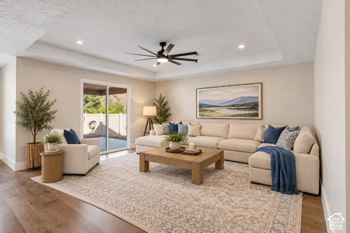Recessed lighting, ceiling fan, wood-finish flooring, sliding glass door, and tray ceiling
