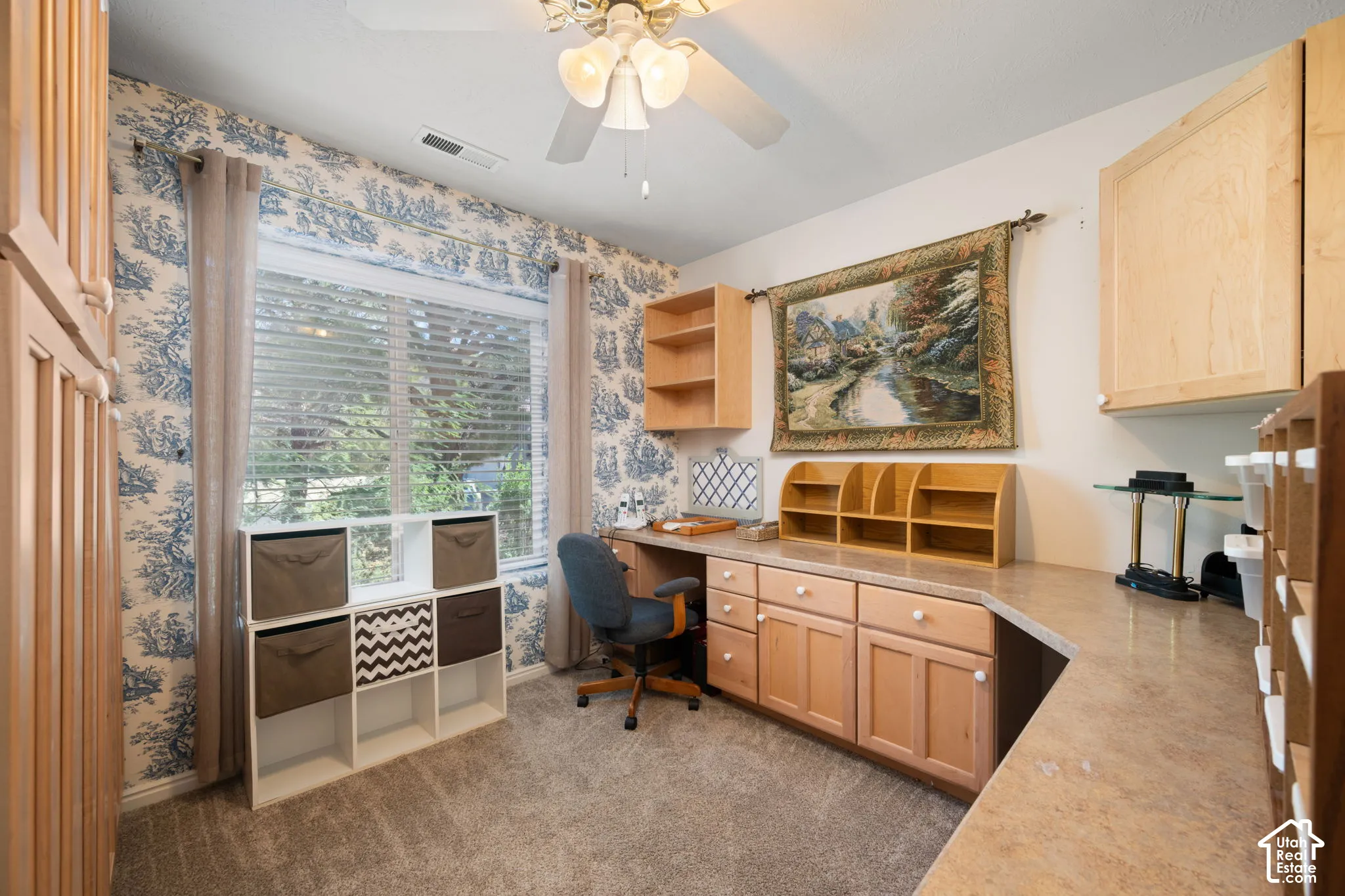 Built-in desk area with wood-finish cabinetry, ample countertop space, and overhead shelving