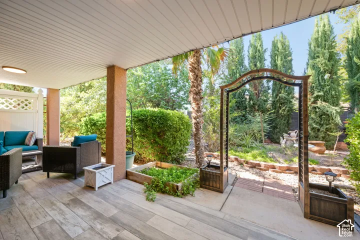 Covered patio featuring wood-finish flooring, support columns, and an integrated ceiling light