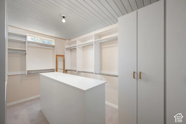 Built-in cabinetry with multiple hanging rods, shelving, and a central storage island