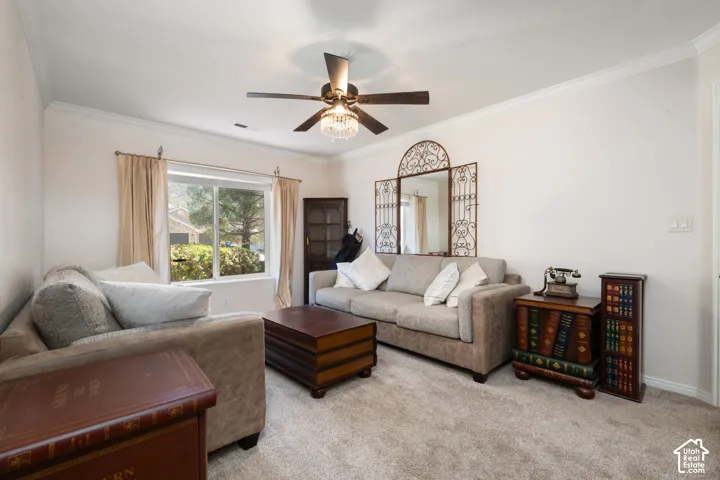 Carpeted flooring, crown molding, and a ceiling fan with integrated lighting