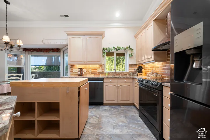 Kitchen featuring a butcher block island, light wood-finish cabinetry, granite countertops, and stone-look flooring