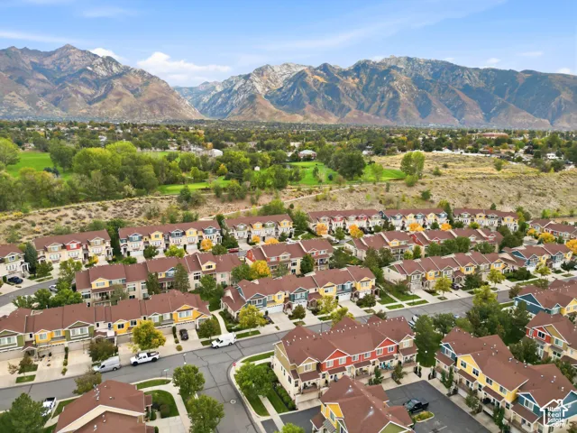 Mountainous backdrop framing a community of multi-story residences with varied exterior colors and brown roofs