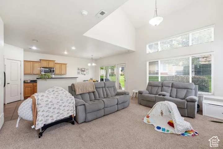 Vaulted ceilings, expansive windows, wood-finish cabinetry, stainless steel microwave, and integrated bar seating