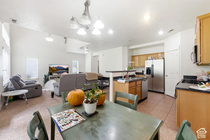 Vaulted ceilings, open concept design, recessed lighting, tile flooring in kitchen, and natural wood cabinetry
