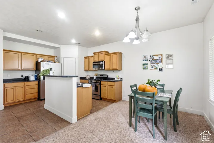 Kitchen with wood-finish cabinetry, stainless steel appliances, and a breakfast bar