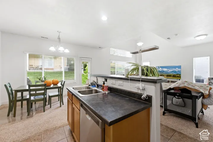 Kitchen with dual basin stainless steel sink, wood-finish cabinetry, and integrated dishwasher