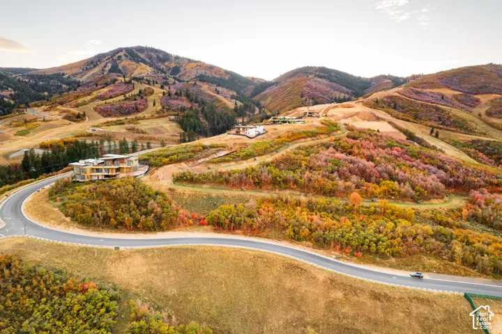 Modern mountain-style residence featuring multiple levels, extensive exterior glazing, and a curved paved driveway