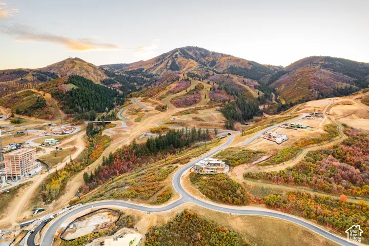 Mountainous terrain with natural vegetation, paved roadways, and multiple developed structures