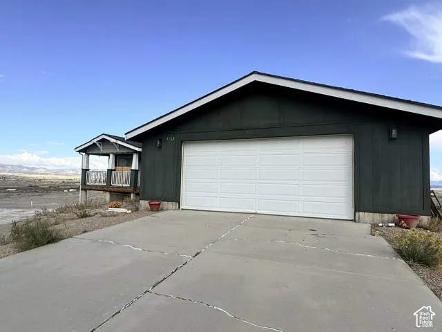 Attached two-car garage with a panel door and sconce lighting