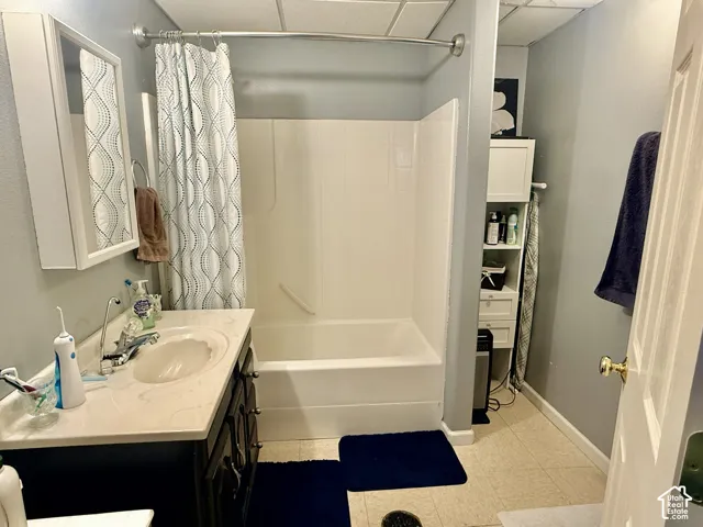 Vanity with an integrated sink and base cabinetry, mirrored medicine cabinet, and a built-in tub with shower capabilities