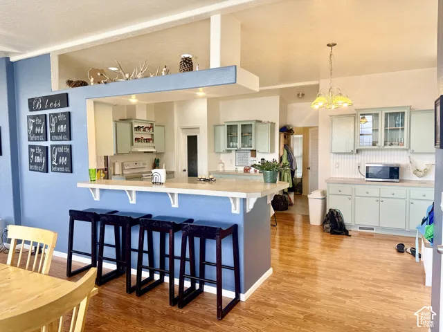 Kitchen featuring wood-finish flooring, recessed lighting, and a breakfast bar with built-in support brackets