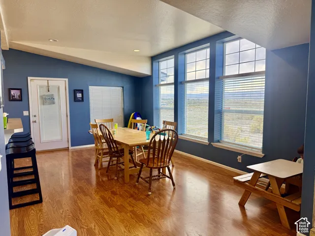 Wood-finish flooring, multiple large windows, and a door with frosted glass panel