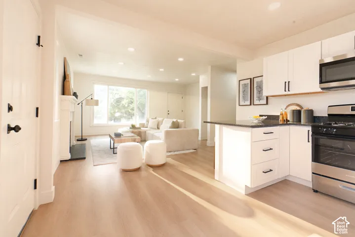 Kitchen featuring white cabinetry, dark countertops, and stainless steel appliances