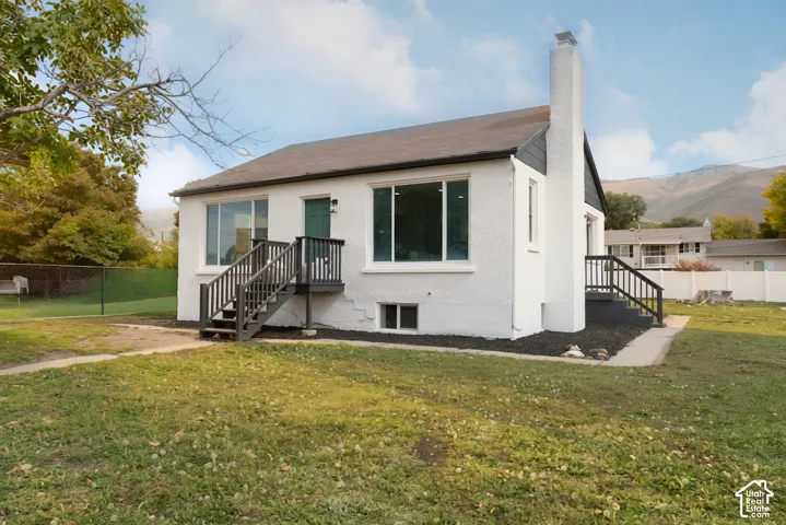 White stucco exterior with a dark roof and chimney