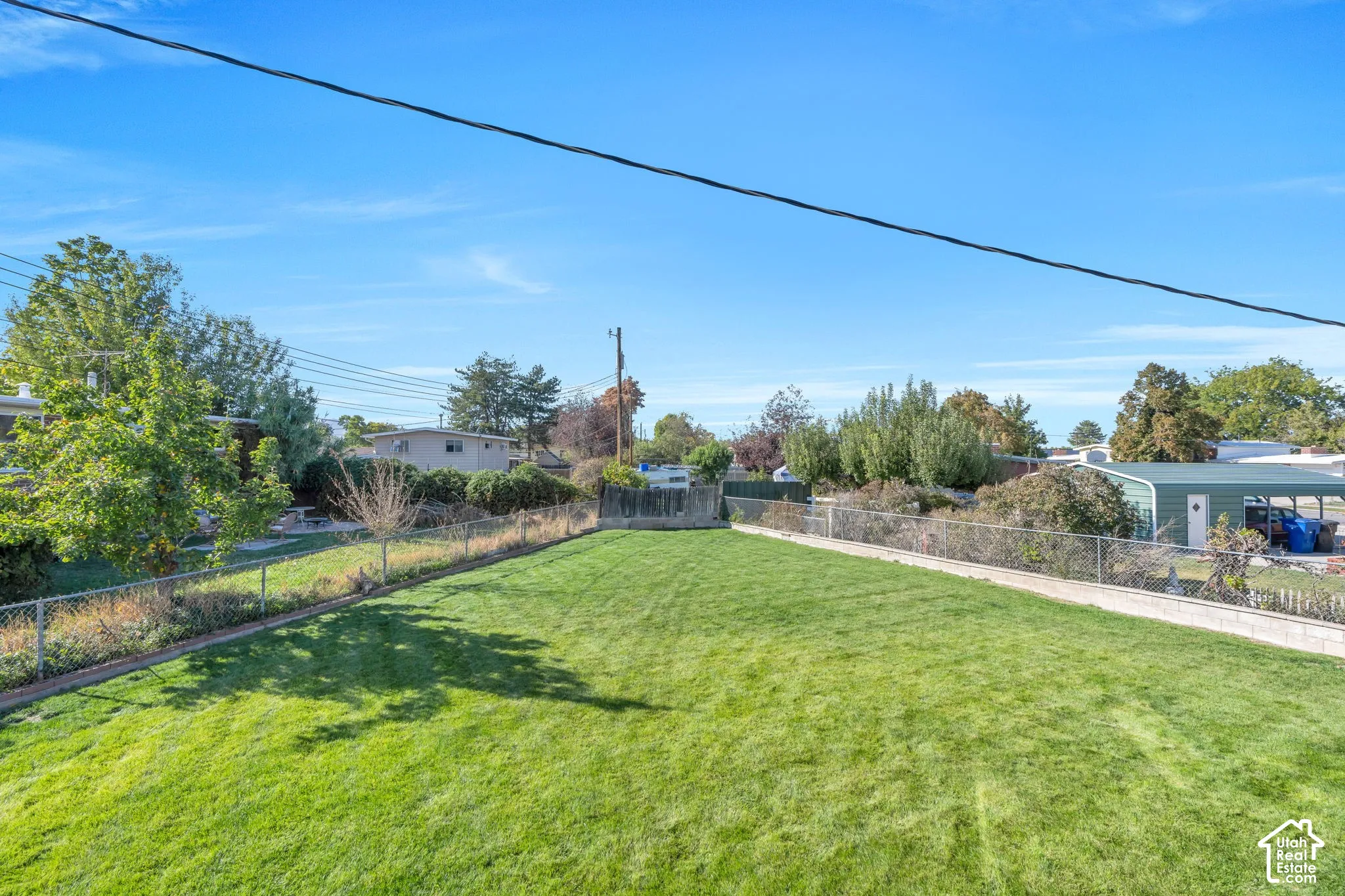 Expansive grassy yard with chain-link fencing