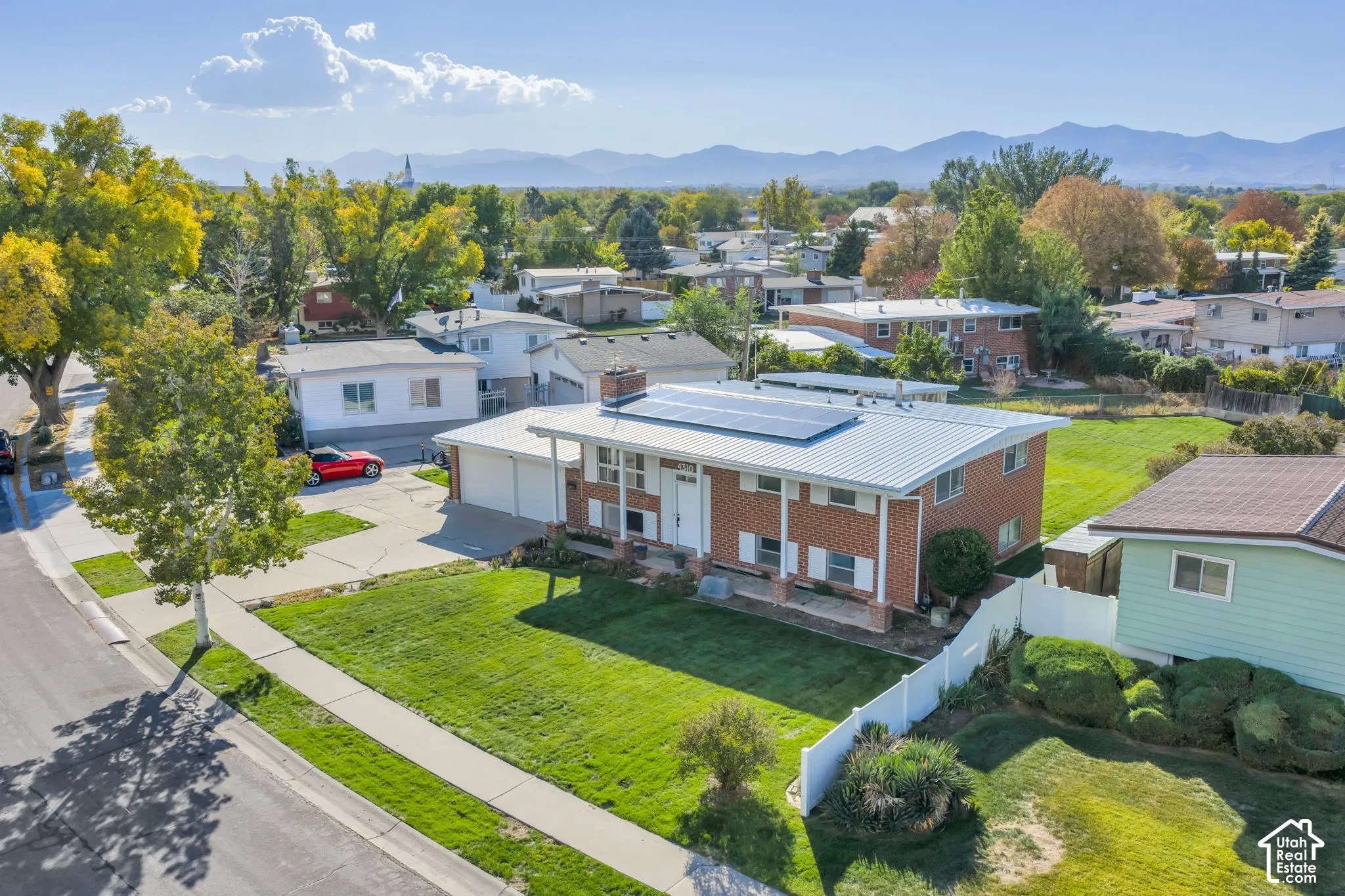 Brick facade residence featuring a metal roof and solar panels