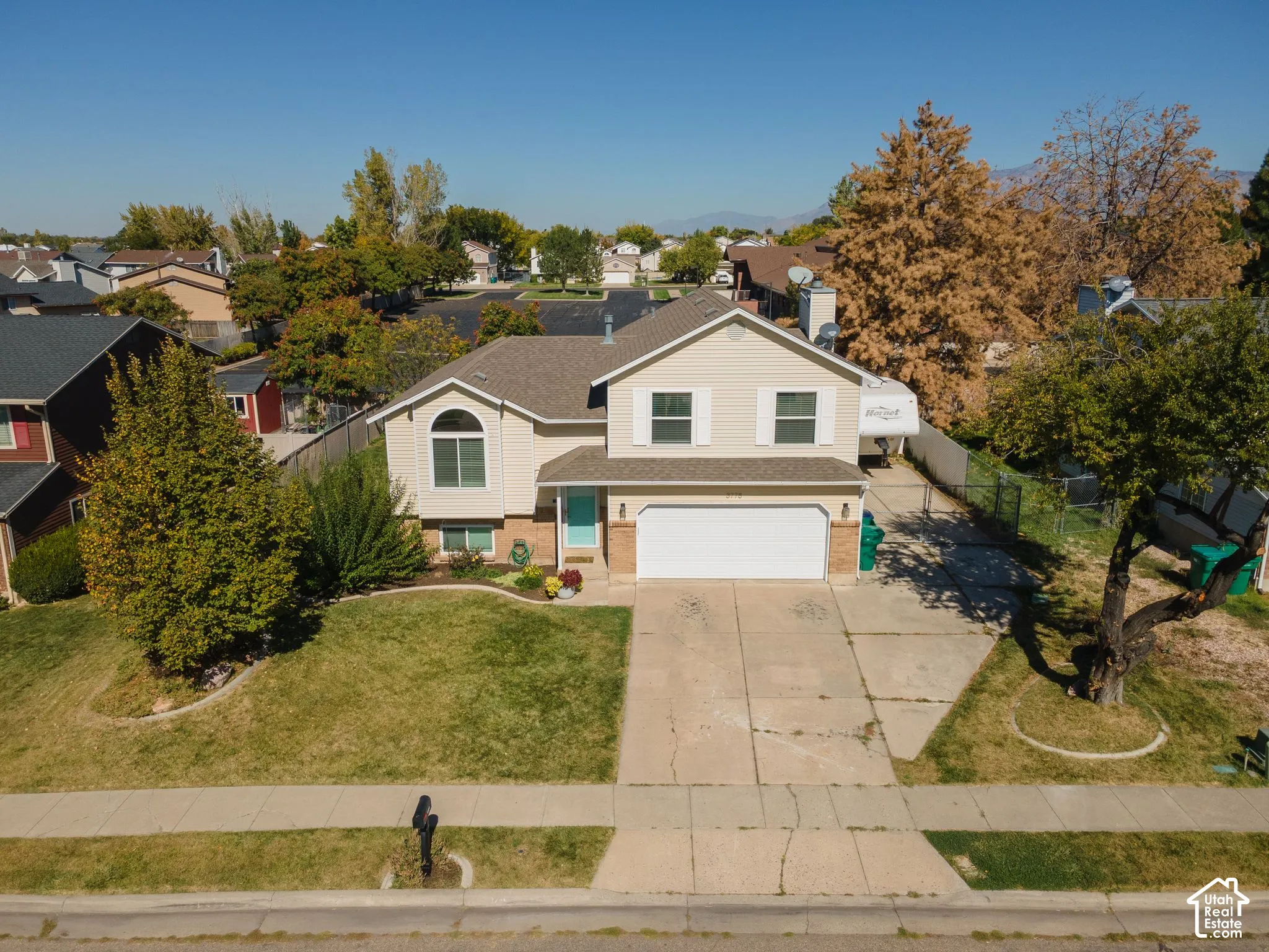 Two-story residence with a two-car garage, concrete driveway, and a front lawn with established landscaping