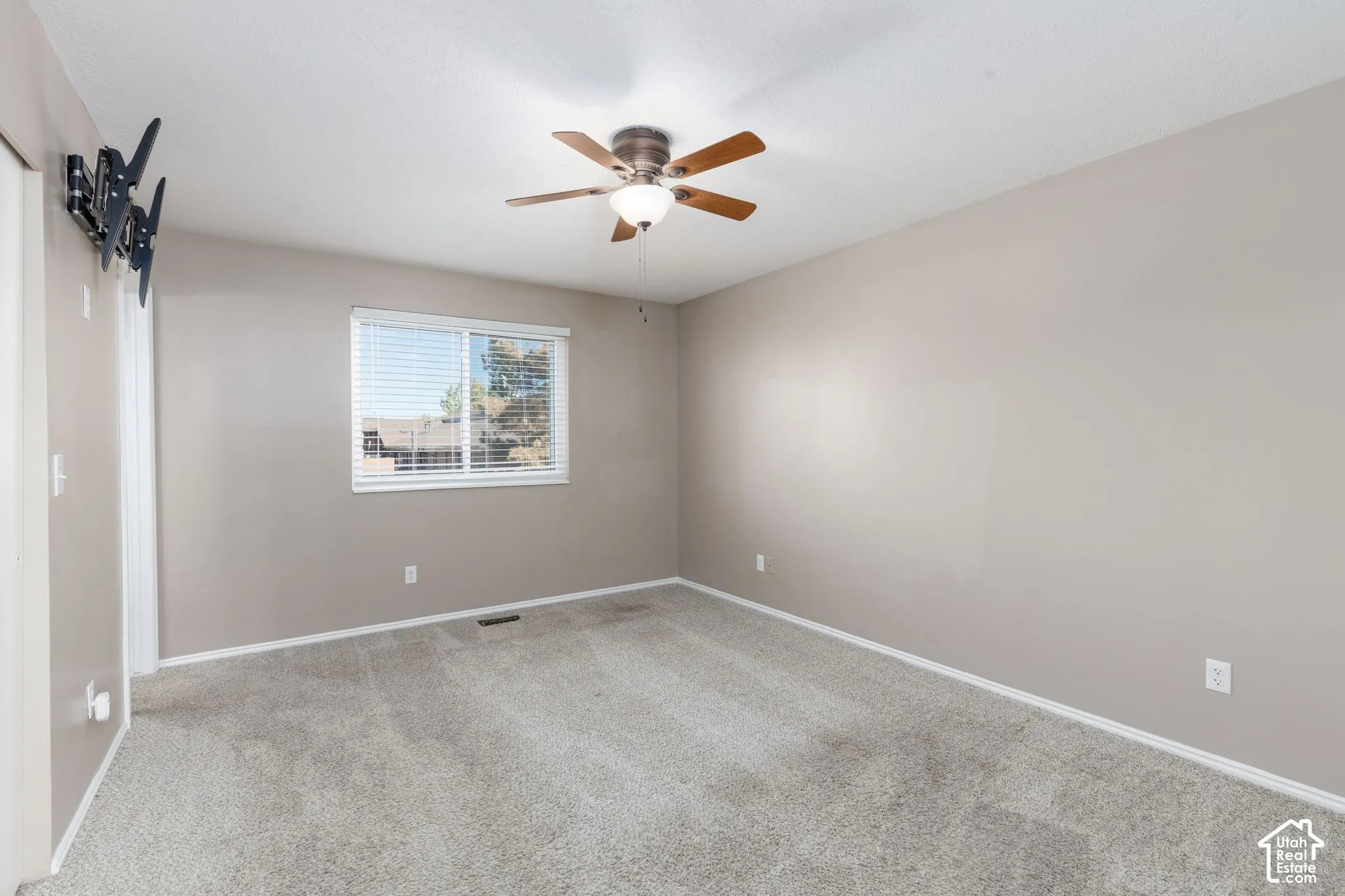 Neutral paint palette with ceiling fan, window with blinds, and wall-to-wall carpeting