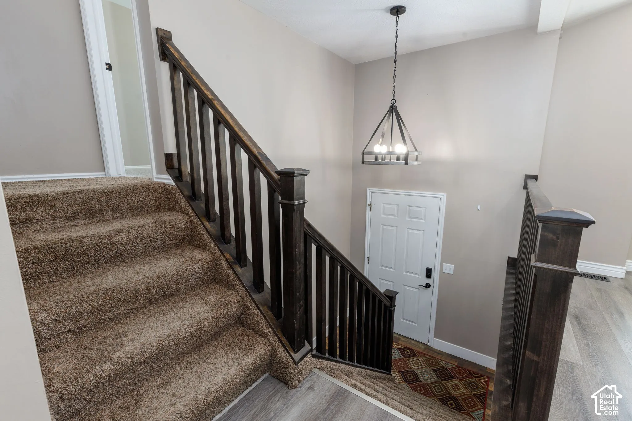 Carpeted staircase with dark wood-finish railing