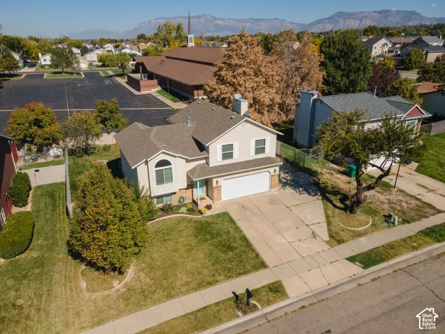 Two-story residence with a two-car garage, concrete driveway, and established landscaping
