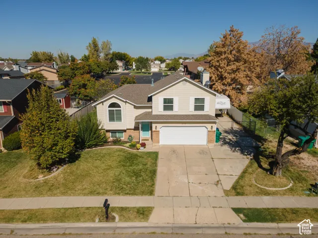 Two-story residence with a two-car garage, concrete driveway, and a front lawn with established landscaping