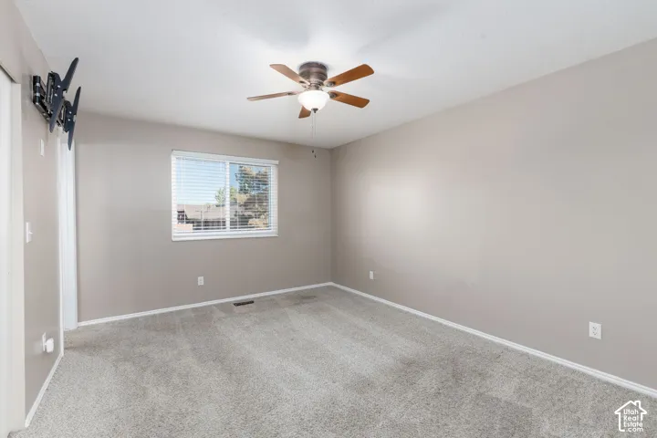 Neutral paint palette with ceiling fan, window with blinds, and wall-to-wall carpeting
