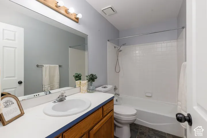 White vanity countertop with an integrated sink, polished chrome faucet, and wood-finish cabinetry