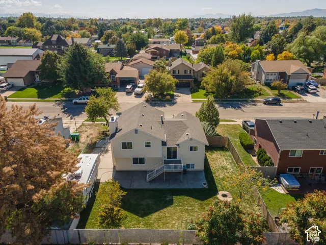 Spacious backyard with a grass lawn, privacy fencing, and mature trees