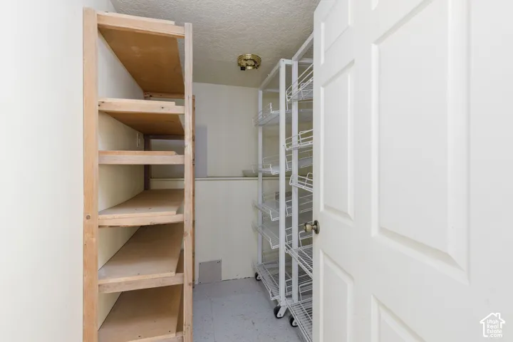 Pantry featuring wood-finish shelving and rolling wire racks