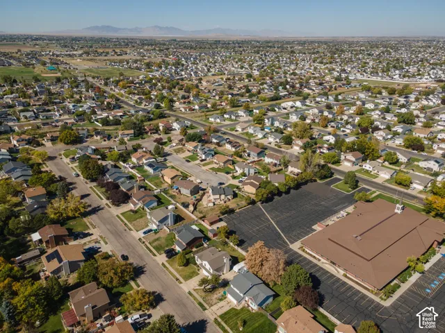 Expansive residential area with numerous detached properties, mountain backdrop, and clear sky
