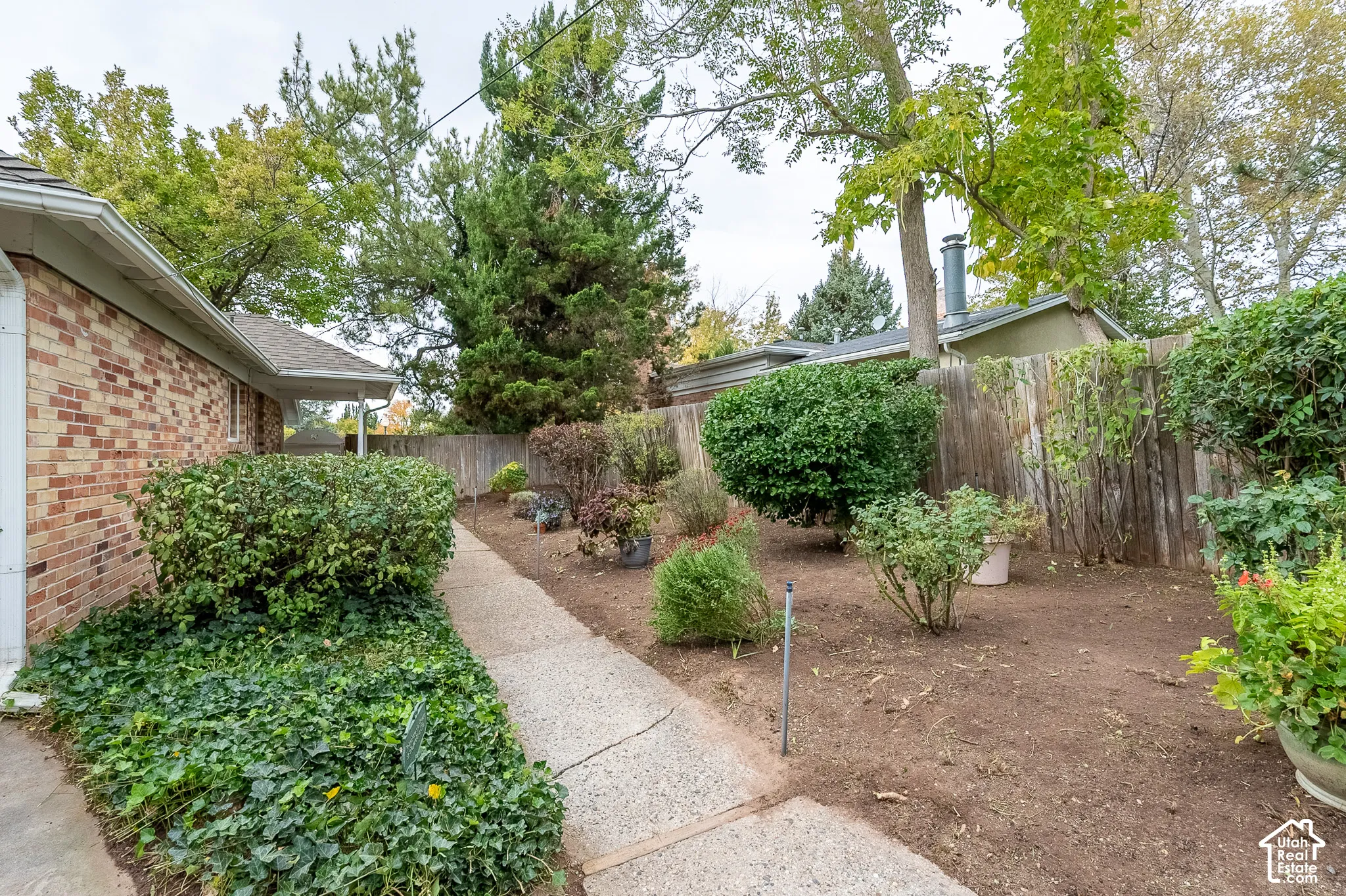 Brick exterior, concrete walkway, and wood perimeter fencing