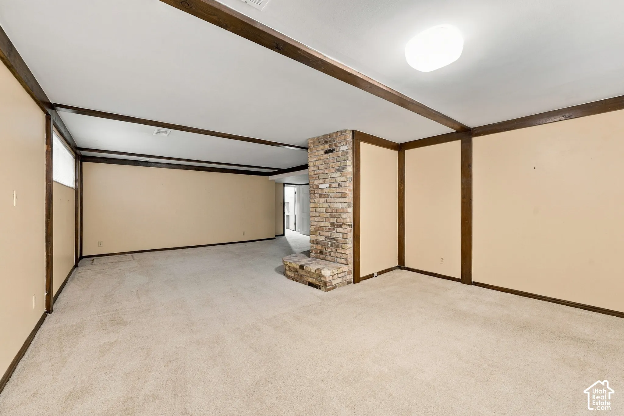 Family Room featuring exposed ceiling beams, a central brick fireplace